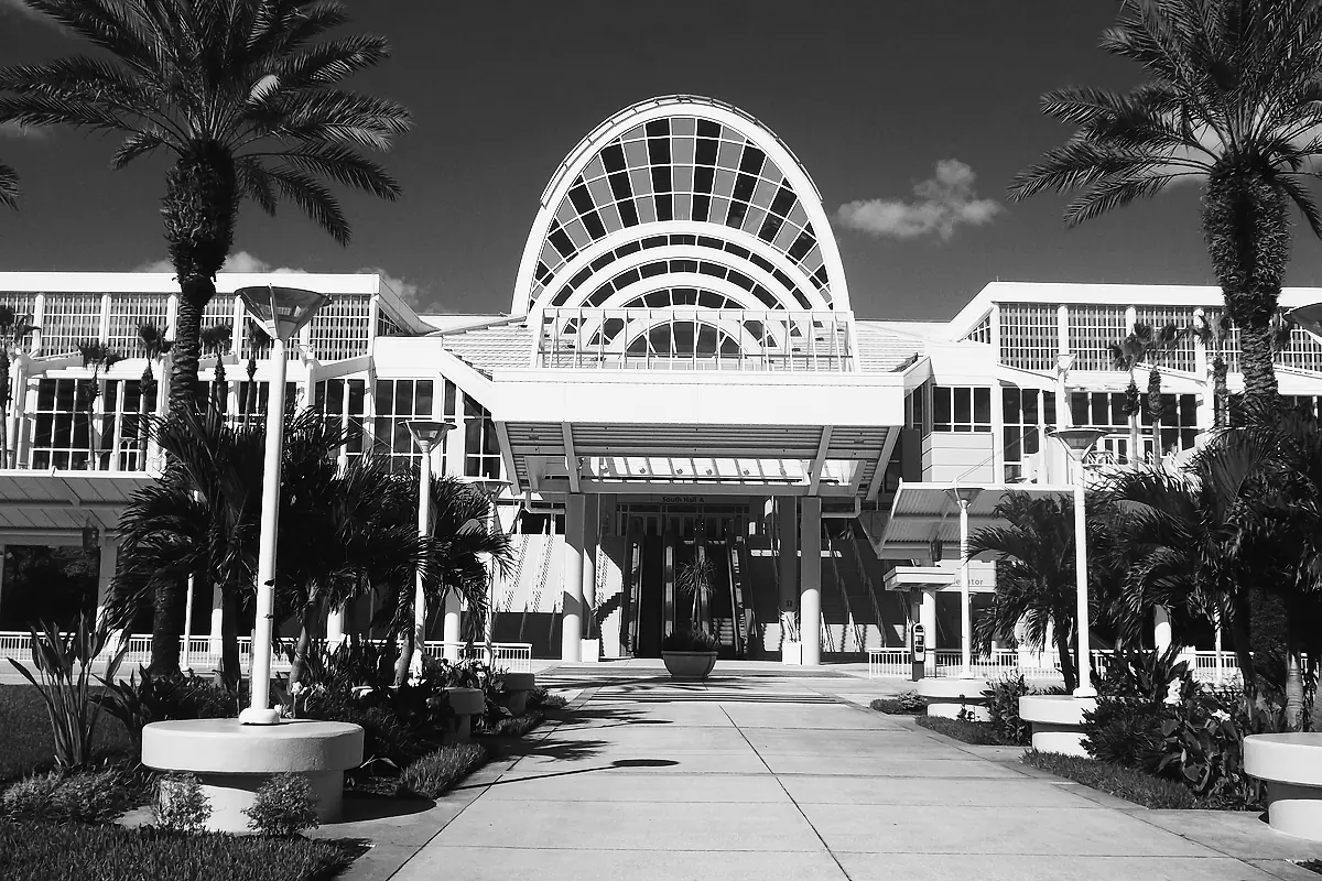 The glass arch over the South Hall entrance of the Orange County Convention Center in Orlando, palms along the walkway.